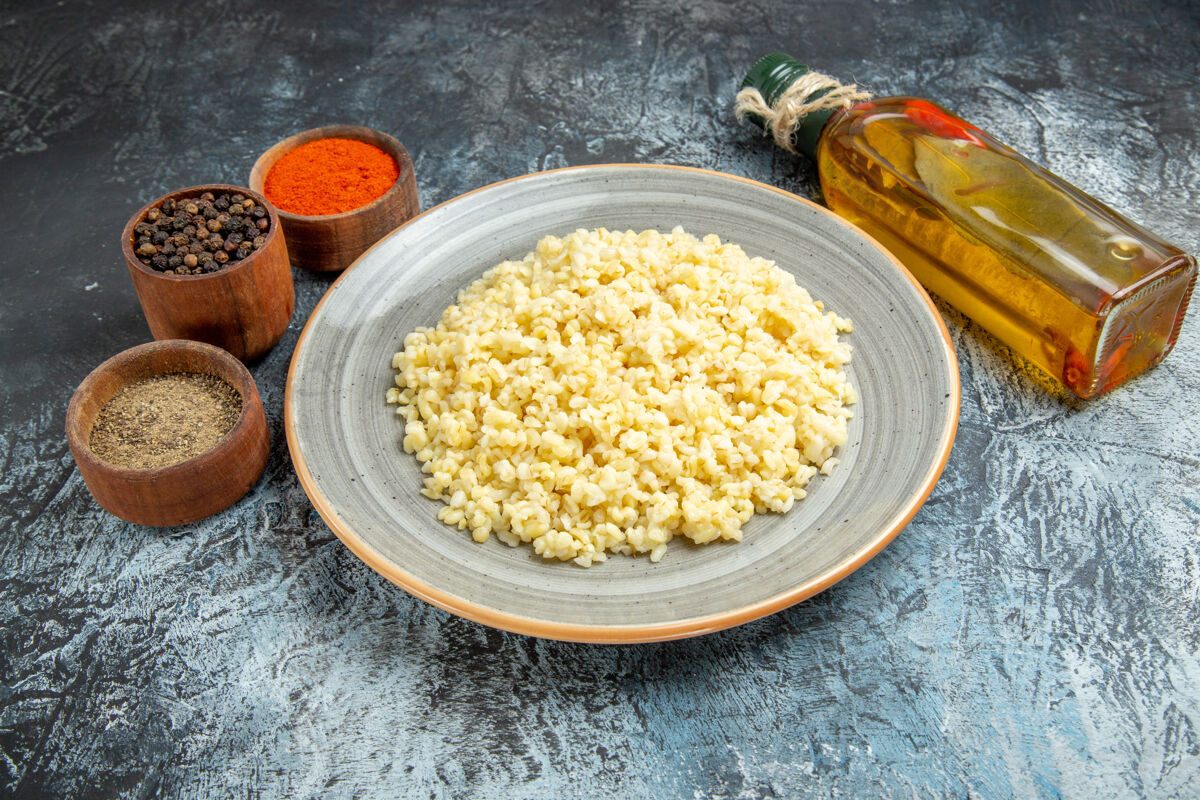 调味品前视图煮熟的珍珠大麦与调味品上轻表面健康食物米饭