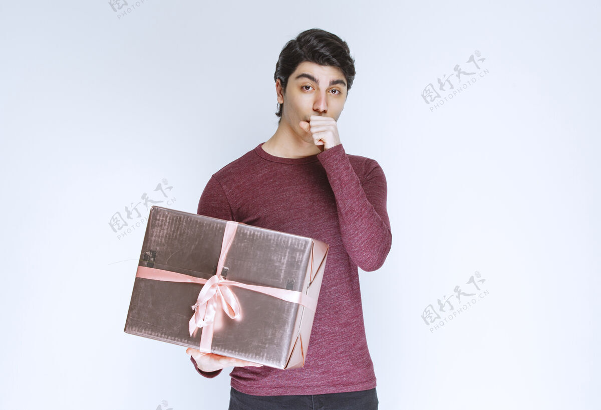 人一个男人拿着一个粉红色的礼盒和烤面包庆祝年轻人快递