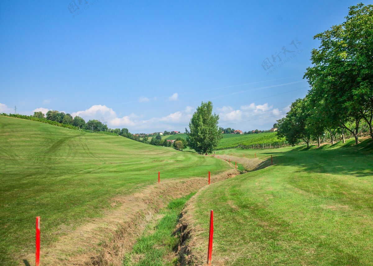 草地在阳光明媚的日子里 zlatigric高尔夫球场上的沟渠用红色标记标出户外欧洲自然