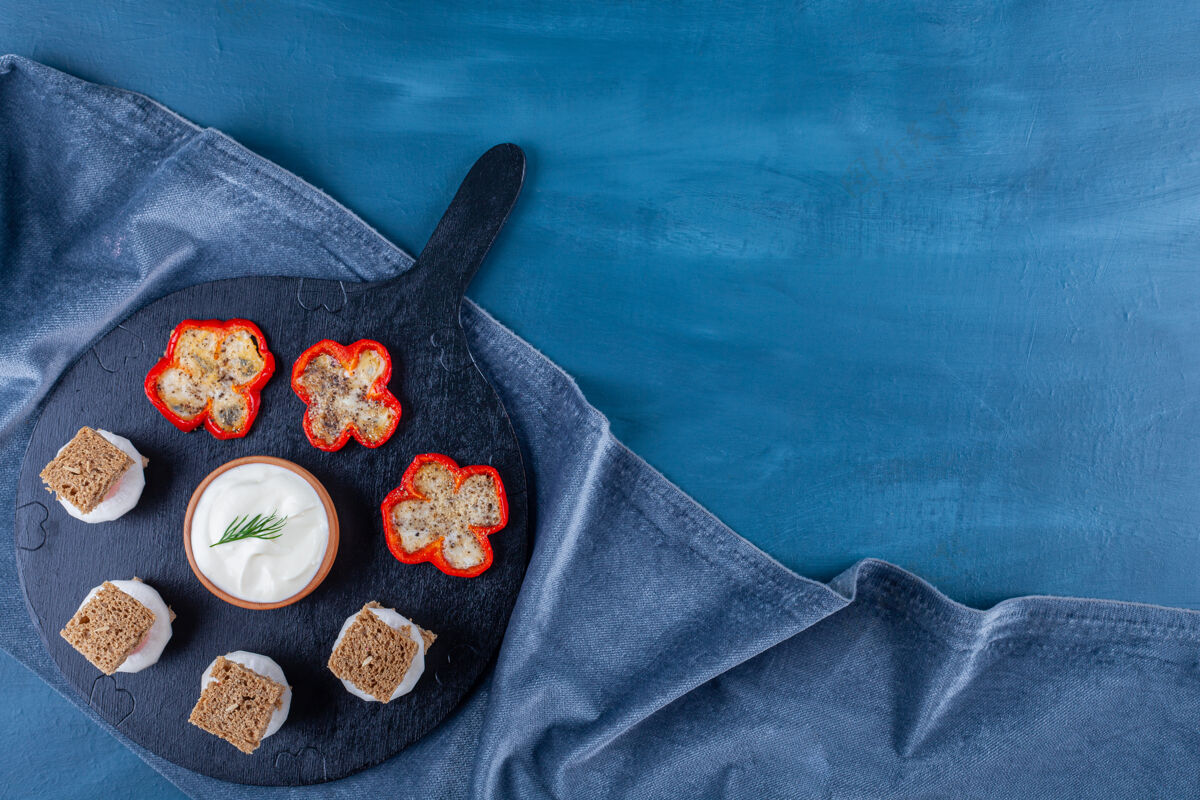 面包在胡椒煎蛋旁边的切好的面包上放一条毛巾 放在蓝色的砧板上美味茶巾胡椒粉