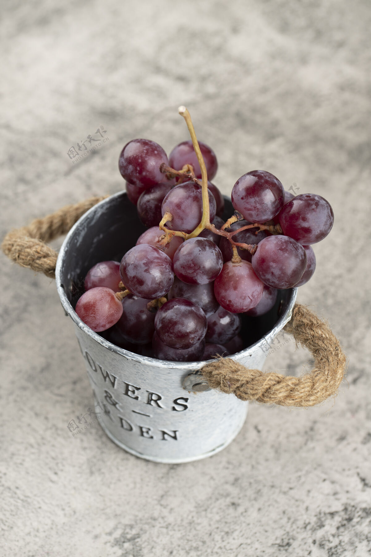 酒庄金属桶的多汁红葡萄石头背景紫罗兰健康新鲜