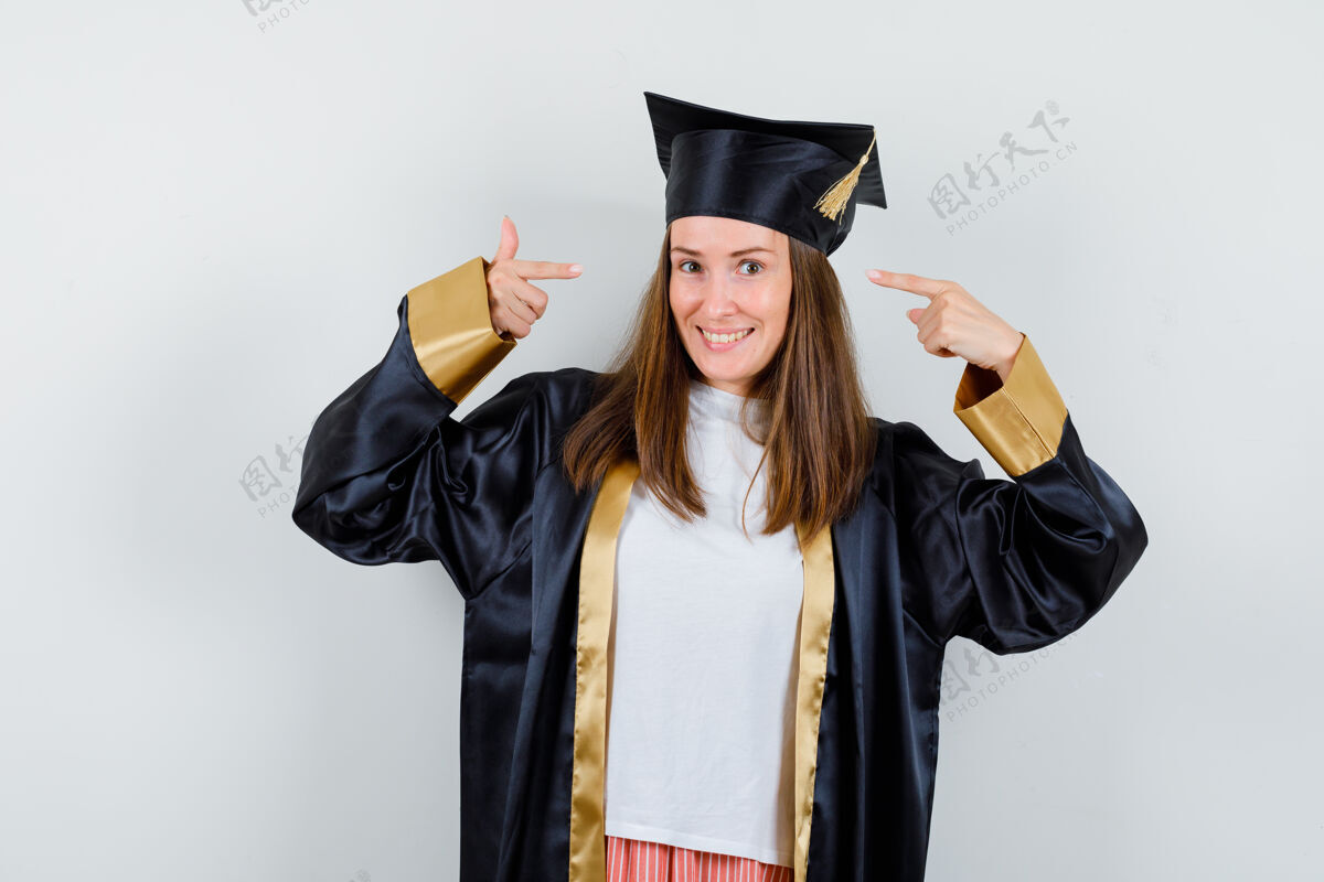 大学一幅女毕业生的肖像画 她穿着学院服指着自己的头 看着欢快的前景色Campus学位学术