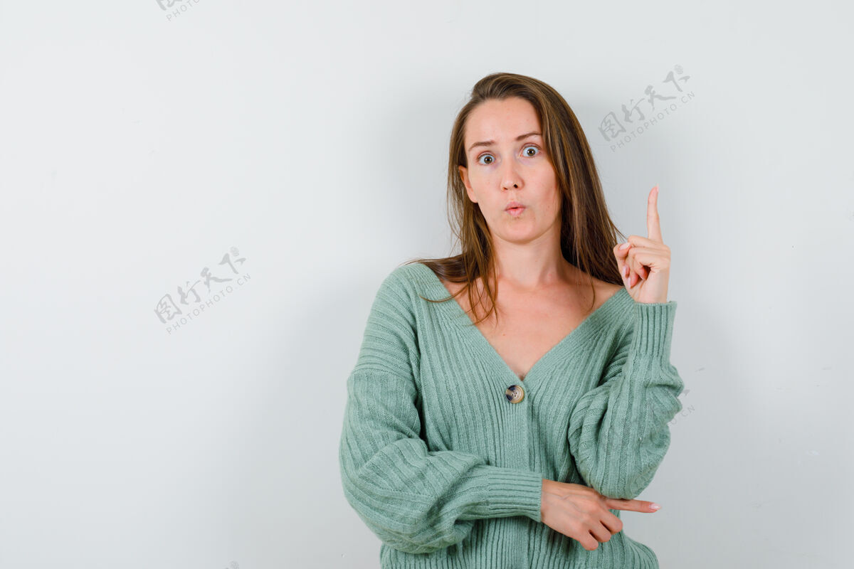 指年轻女孩用尤里卡手势举起食指 穿着针织衫的食指指向右边 表情严肃正视图提高针织销售