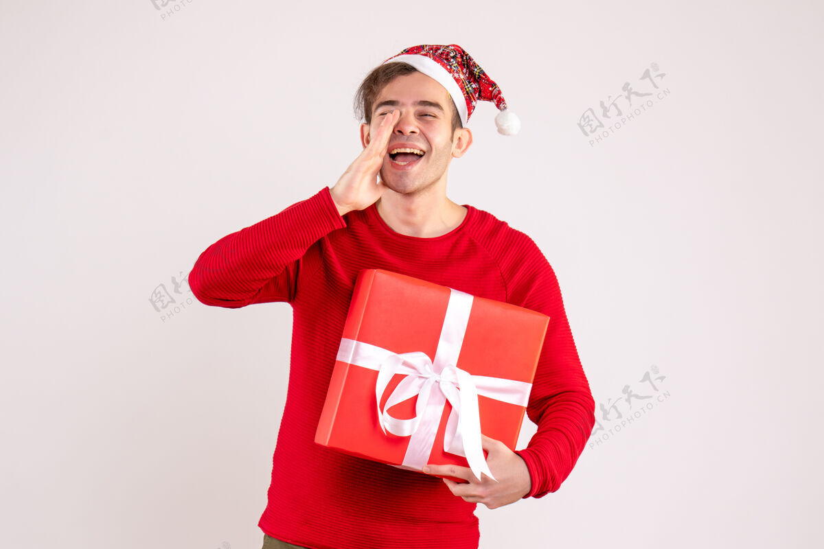 呼叫前视图戴圣诞帽的年轻人在白色背景上呼唤某人帽子背景圣诞节