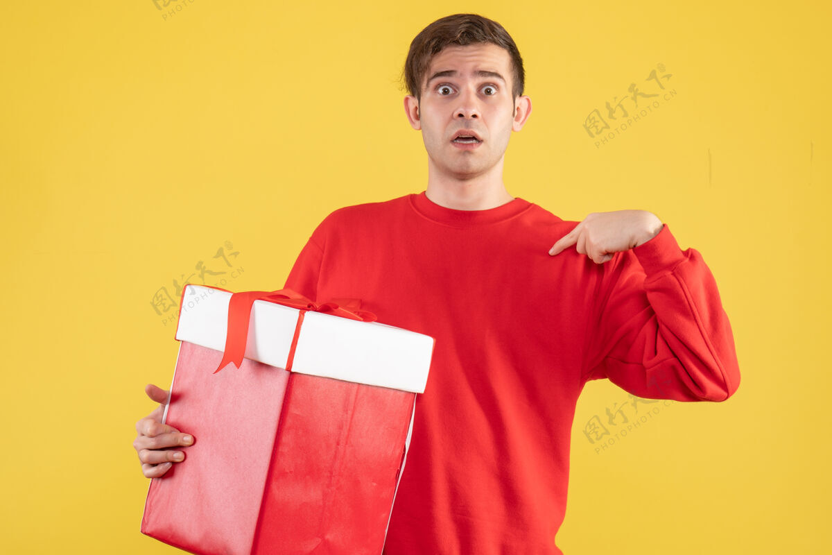 毛衣正面图穿着红色毛衣的年轻人站在黄色的背景上手持人物成人
