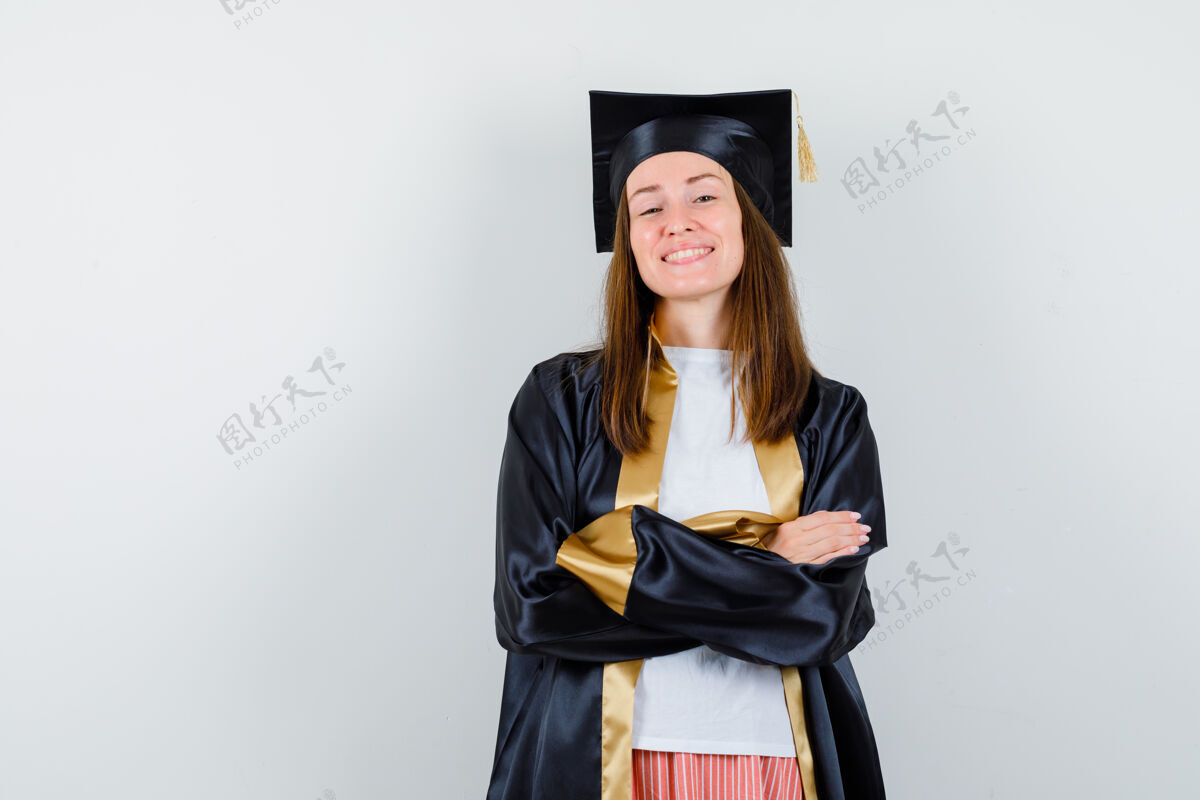 年轻身着学院服的女毕业生交叉双臂站在那里 神情自豪 俯视前方多样性成功Campus