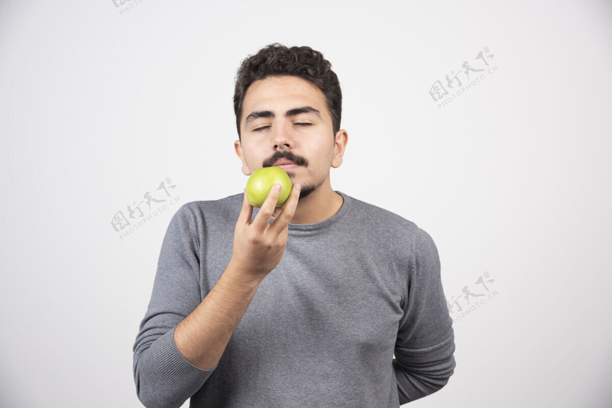 男性饥饿的人闻到青苹果的味道饥饿成人水果