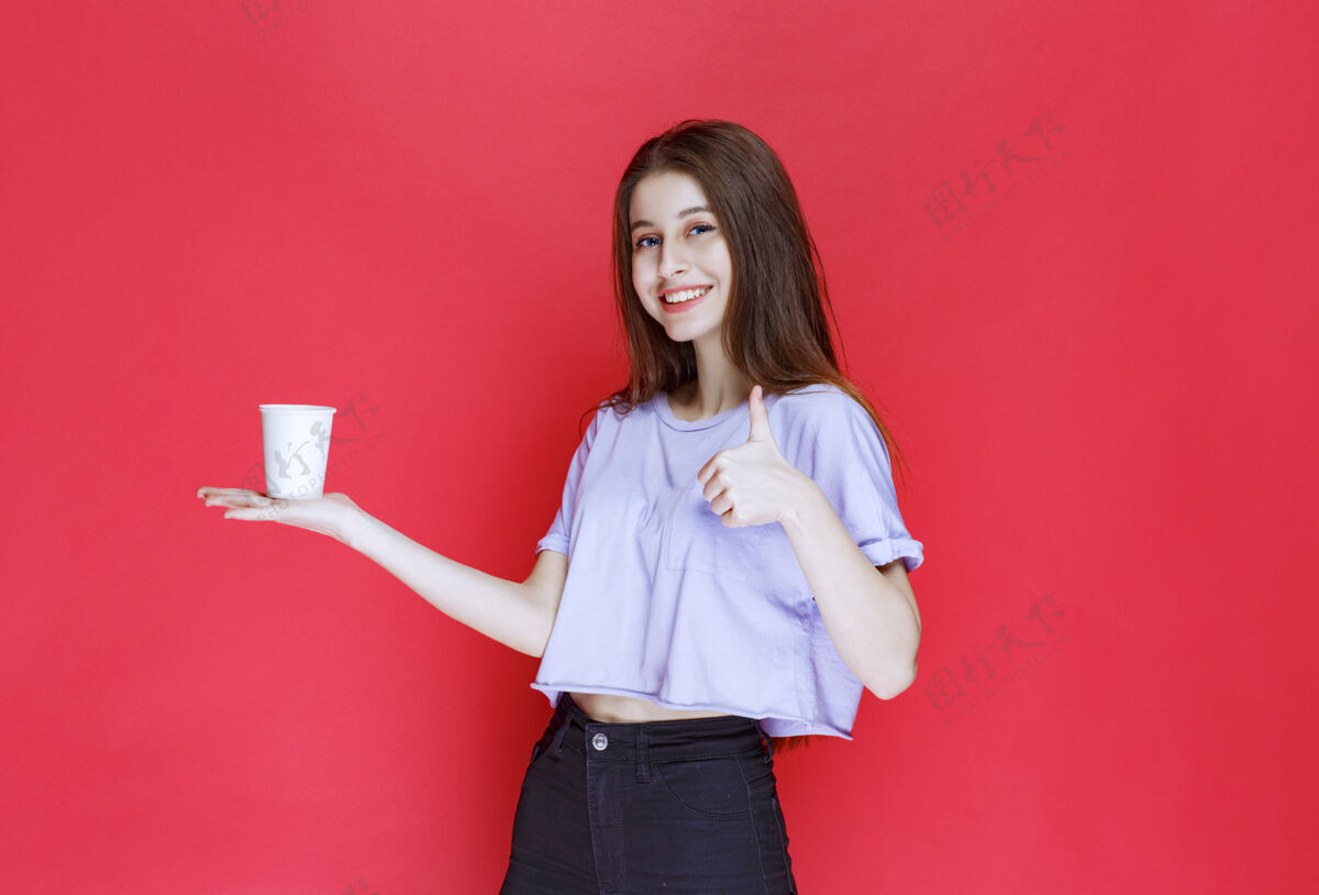 茶年轻女子手持白色一次性水杯 露出满意的表情休闲人口味