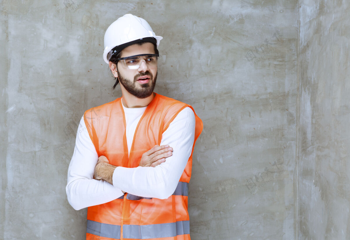 工人戴着白色头盔和护目镜的工程师双手交叉 摆出专业的姿势姿势男性员工