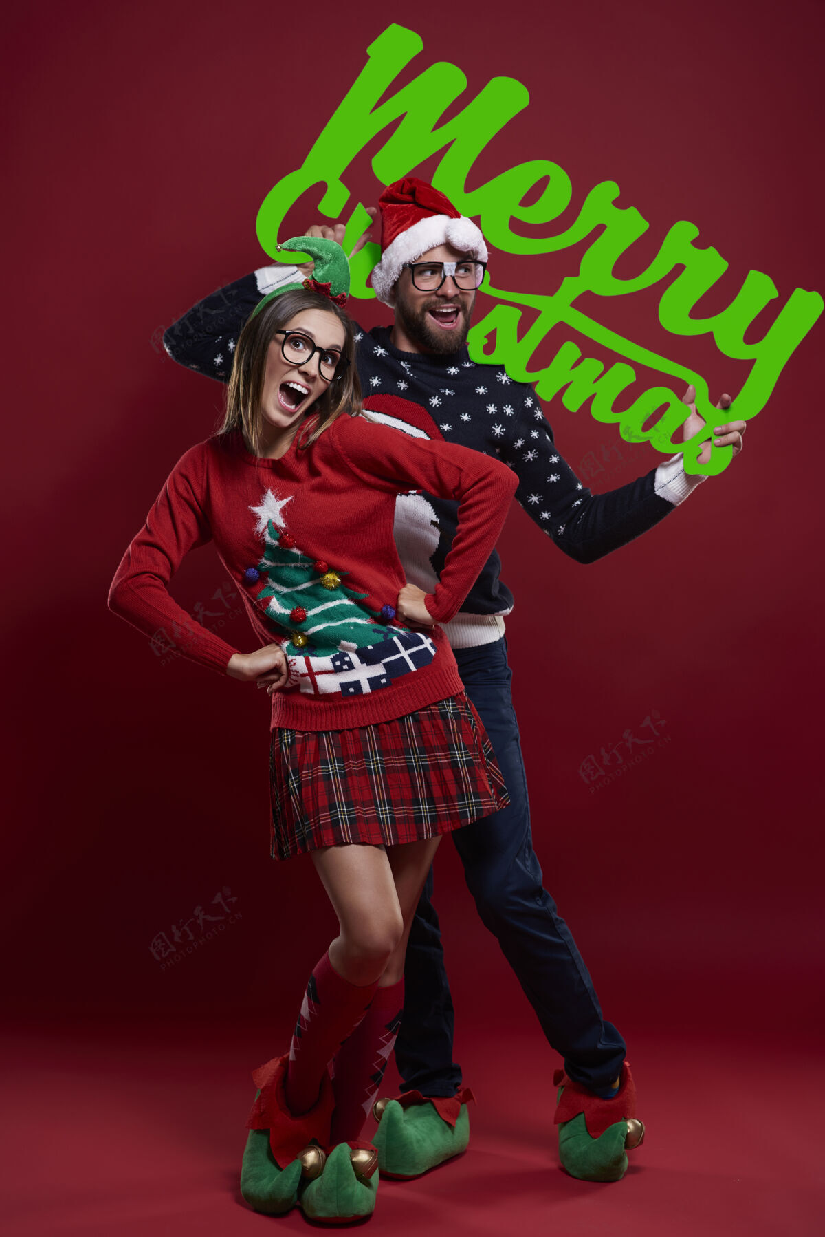 眼镜穿着圣诞服装的快乐的书呆子夫妇精灵愿望情侣