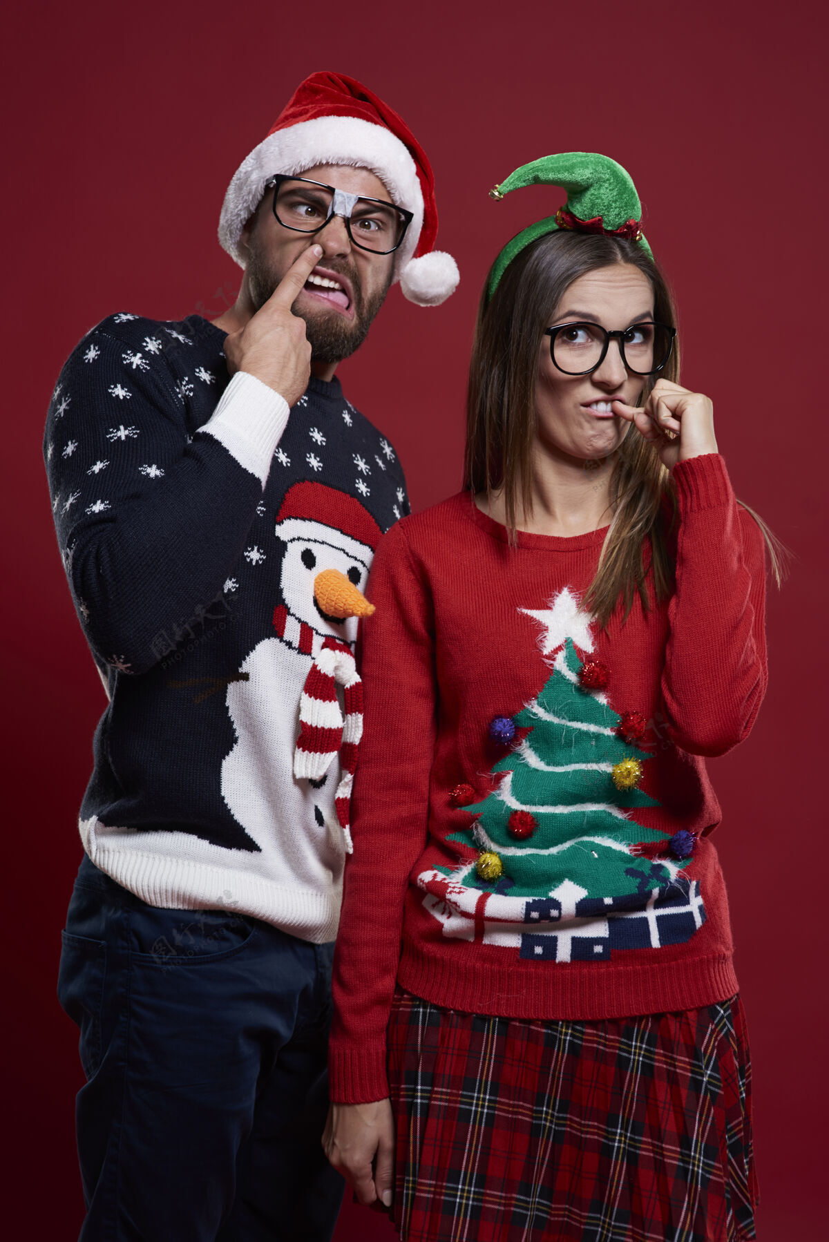 极客穿着奇怪圣诞服装的年轻夫妇女人手势书呆子