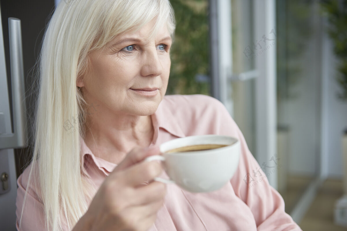 老年妇女在阳台上享受美味咖啡的熟女特写镜头成人休闲服早餐