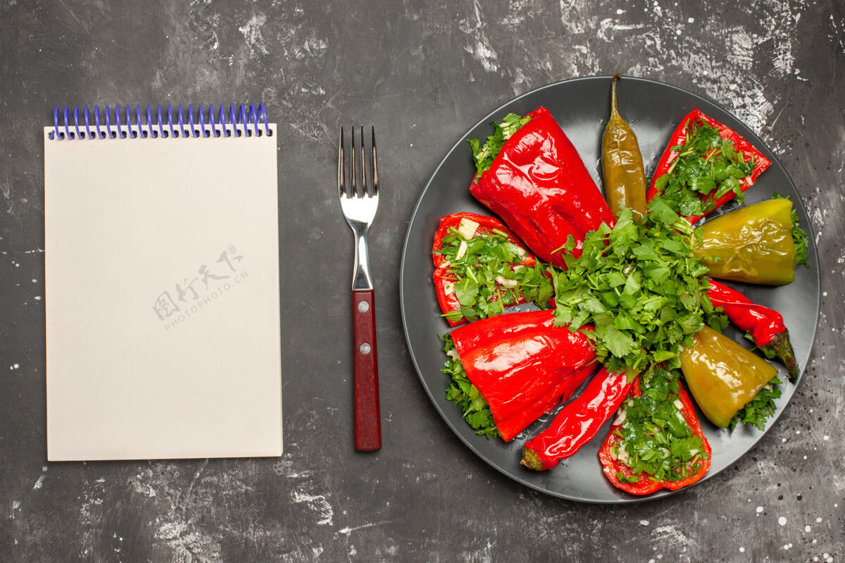 香草胡椒盘顶视图胡椒盘上有草药白色笔记本叉子食物胡椒午餐
