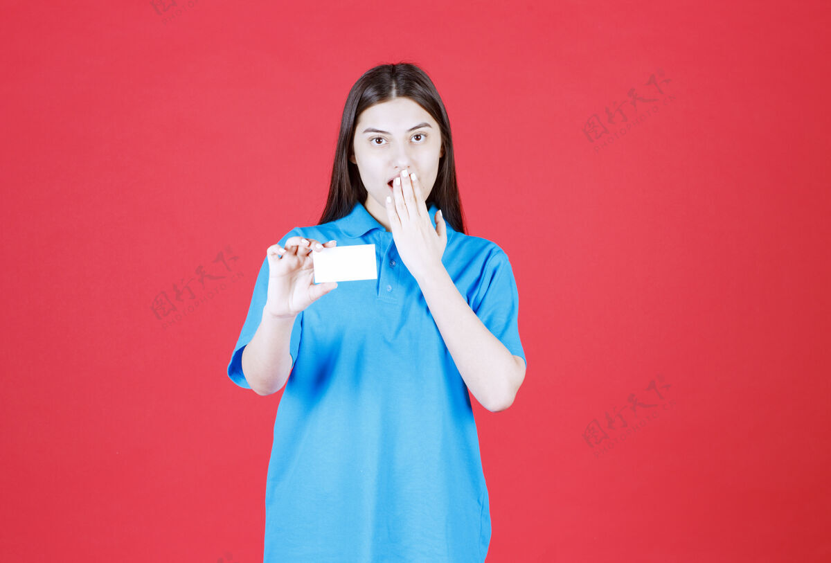 人穿蓝衬衫的女人出示名片 感到既惊讶又害怕姿势兴奋名片
