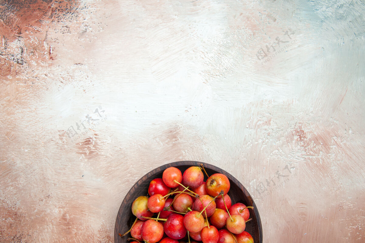 成熟樱桃顶视图一碗开胃的红黄色樱桃摆在桌上健康樱桃有机