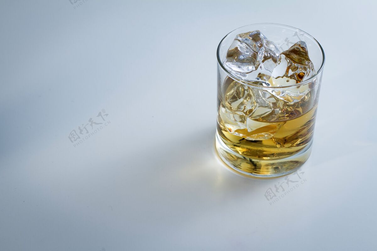 威士忌高角度拍摄的一杯冰和一些威士忌隔离在一个白色的背景液体立方体食物
