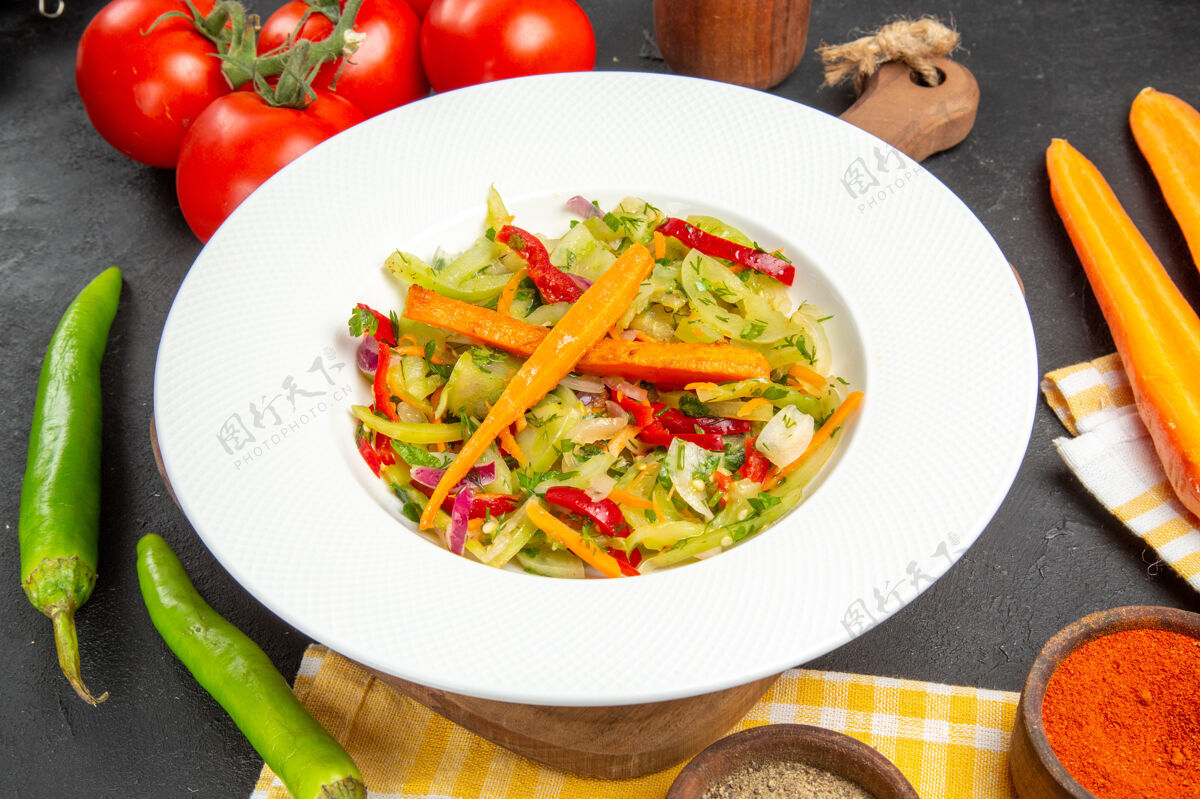美味侧面特写蔬菜辣椒香料西红柿色拉在砧板桌布上盘子桌布西红柿
