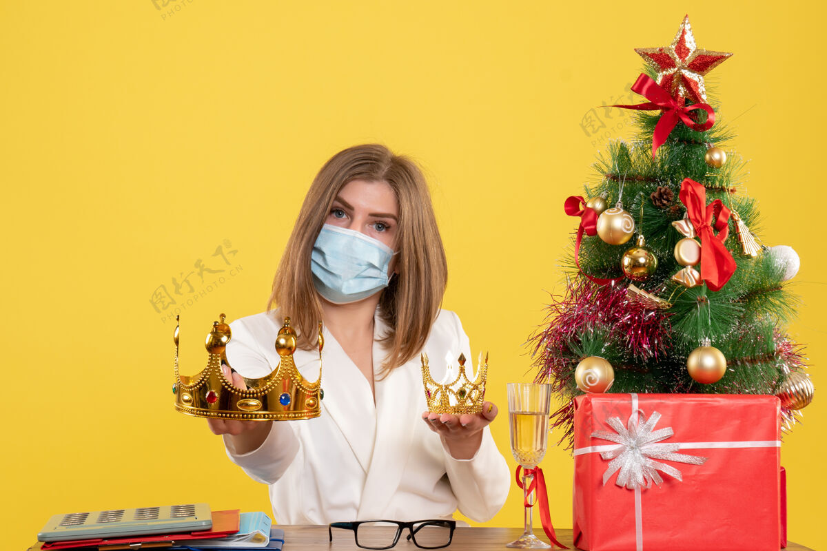 肖像正面图：戴着无菌面罩戴着皇冠的女医生圣诞节绝育人物