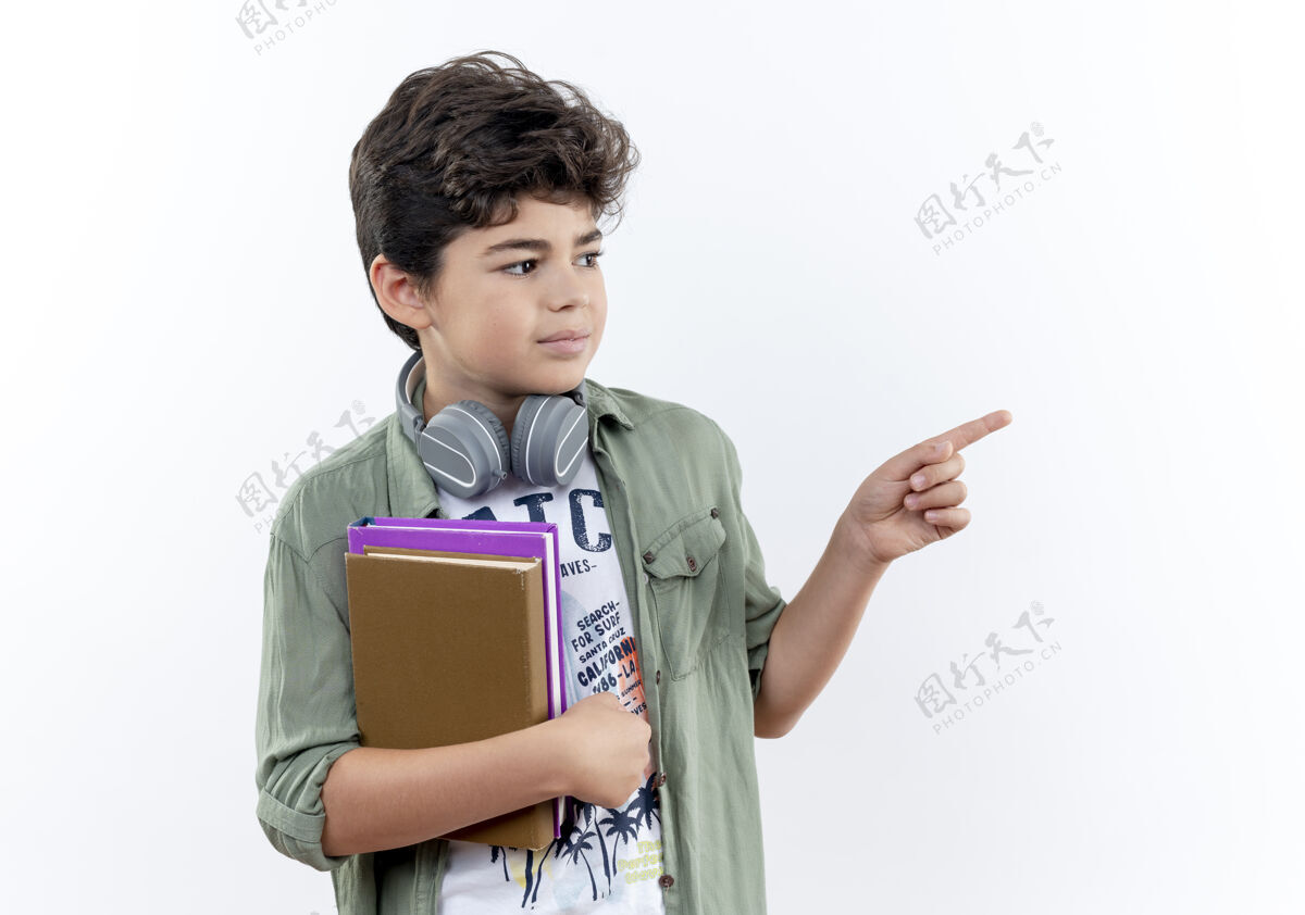 点看着身边戴着耳机拿着书的小男生 指着旁边隔离着的白色背景和复印空间耳机小学生小