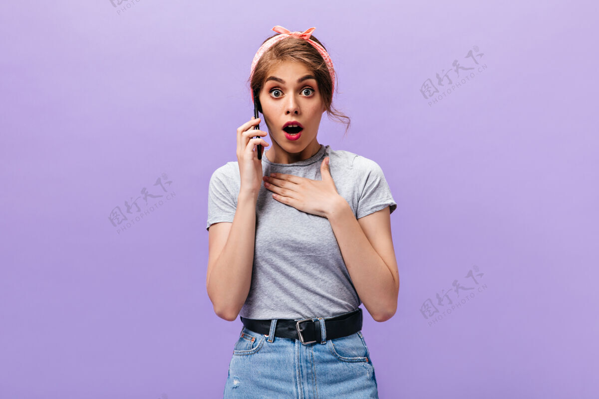 头带一位身着灰色套装的女士在电话里聊天一位穿着粉色大手帕和牛仔裙 系着黑色腰带的时髦酷女人正对着镜头看呢紫色微笑一件