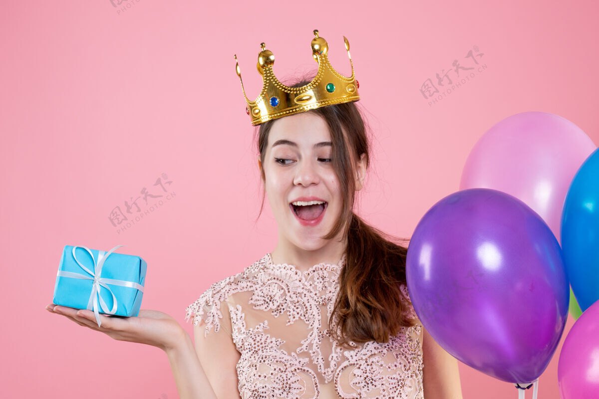 礼物特写前视图可爱的聚会女孩与皇冠举行的礼物和气球微笑皇冠粉红色