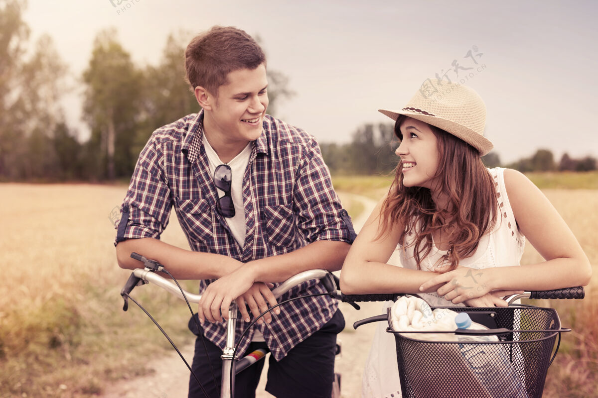 年轻人骑自行车的幸福夫妇的画像自行车田地聚会