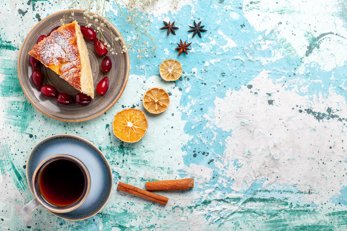 饼干顶视图蛋糕片新鲜的红山茱萸和一杯茶蓝色背景水果蛋糕烤派饼干甜咖啡茶切片