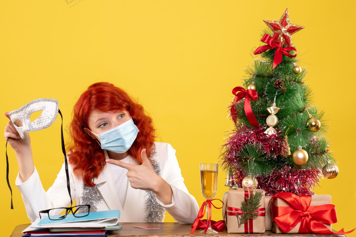 面具正面图女医生戴着无菌口罩举着派对口罩在圣诞节前后亮相礼物举行消毒