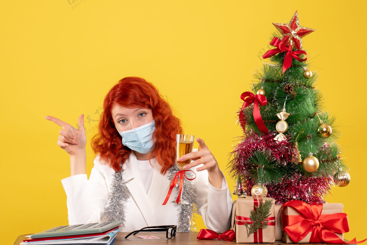 美丽前视图女医生用香槟庆祝圣诞节病毒庆祝花