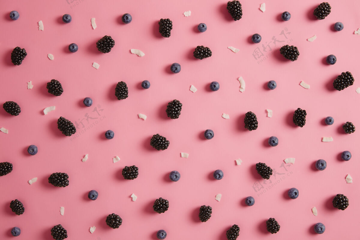 美味头顶拍摄多汁蓝莓和黑莓 椰子片在玫瑰色的背景夏季时间和营养概念健康的有机成熟季节性浆果准备甜点营养食品素食有机营养