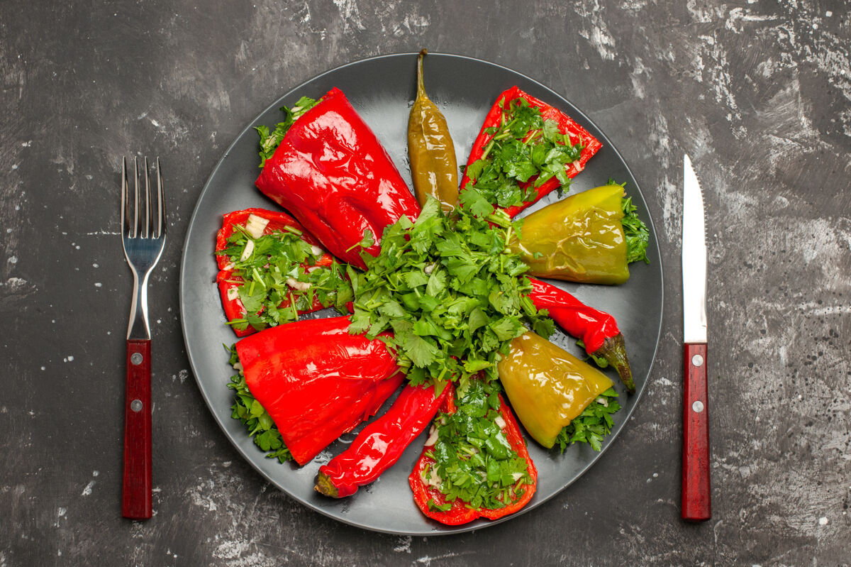 草药顶部特写镜头辣椒盘子五颜六色的辣椒和草药之间的叉子和刀沙拉饮食食物