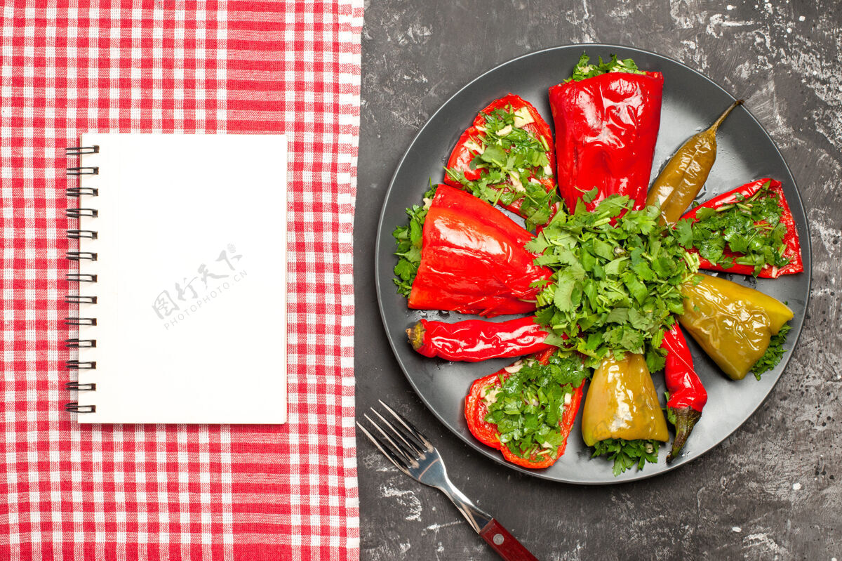 盘子上面的特写镜头辣椒板叉子辣椒板白色笔记本在桌布上锅蔬菜晚餐
