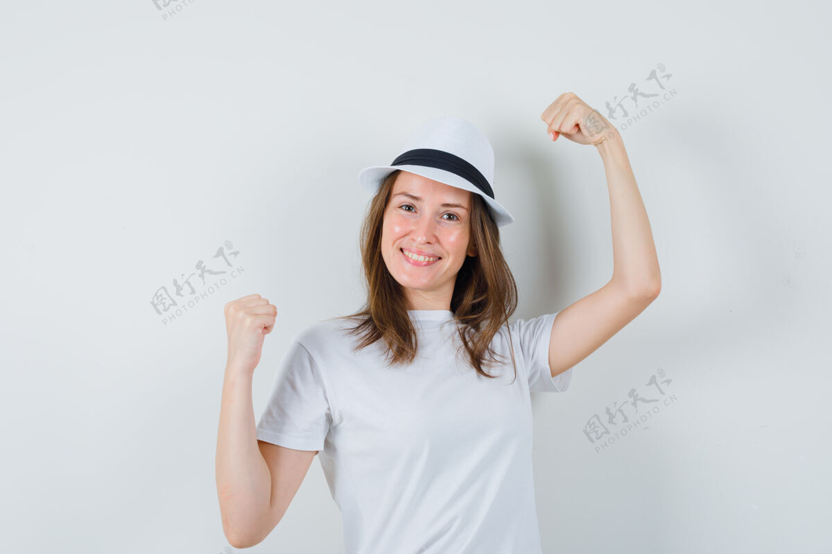 帽子一个年轻女孩戴着白色t恤帽子展示着赢家的姿态 看上去很幸运童年幸运小