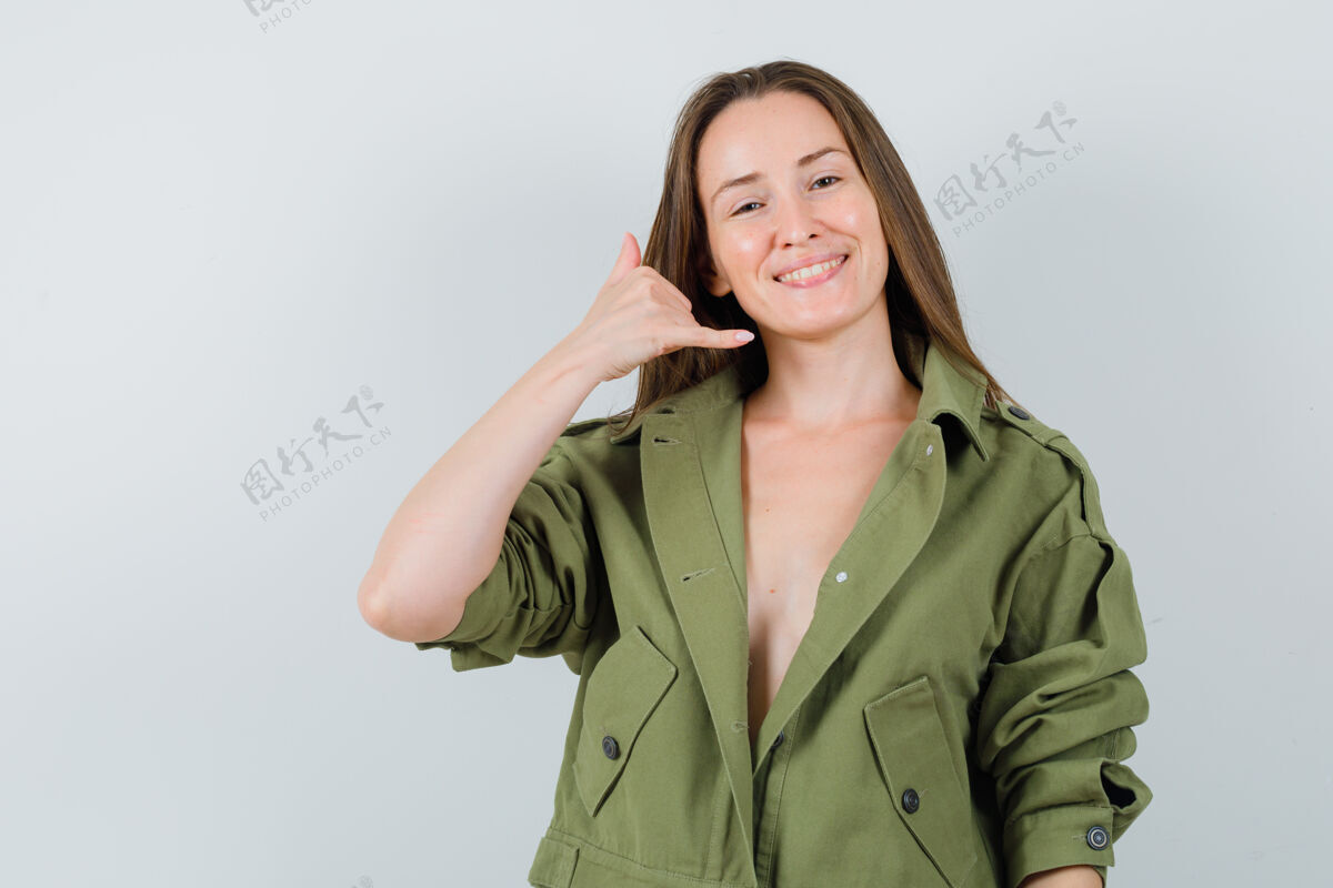 女士一位身穿绿色夹克的年轻女士展示着打电话的姿势 看上去很自信黑发休闲时尚