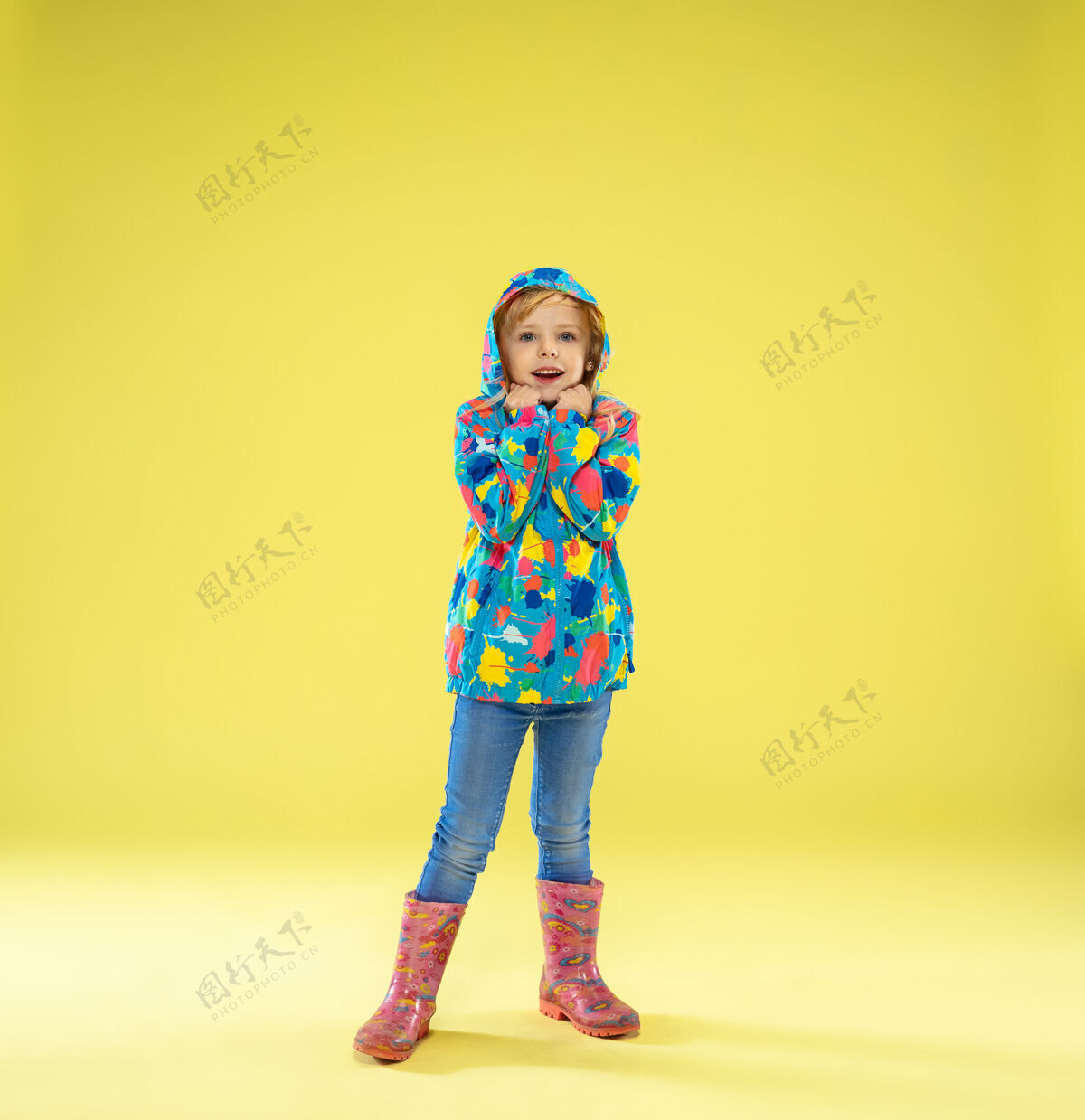 学校一个穿着雨衣 手持黄色彩虹色雨伞的时髦女孩的完整肖像孩子室内明亮