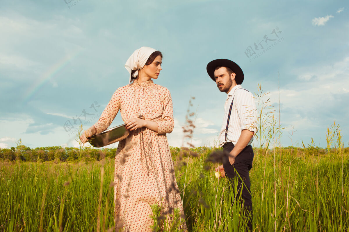 青年一对穿着乡村服装的夫妇在田野里乡村家庭绿色
