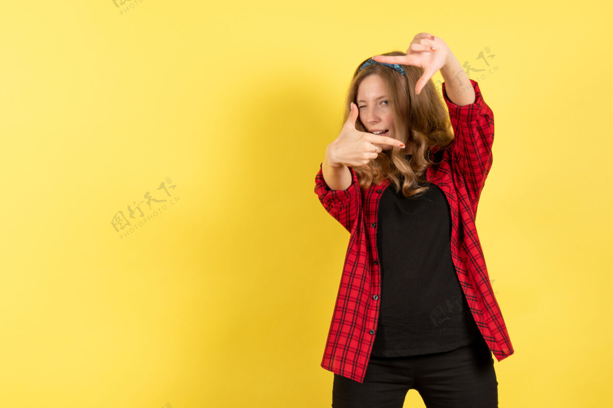 视图正面图穿着红色格子衬衫的年轻女性在黄色背景上摆姿势人类女孩情感色彩模特女人衬衫漂亮女士