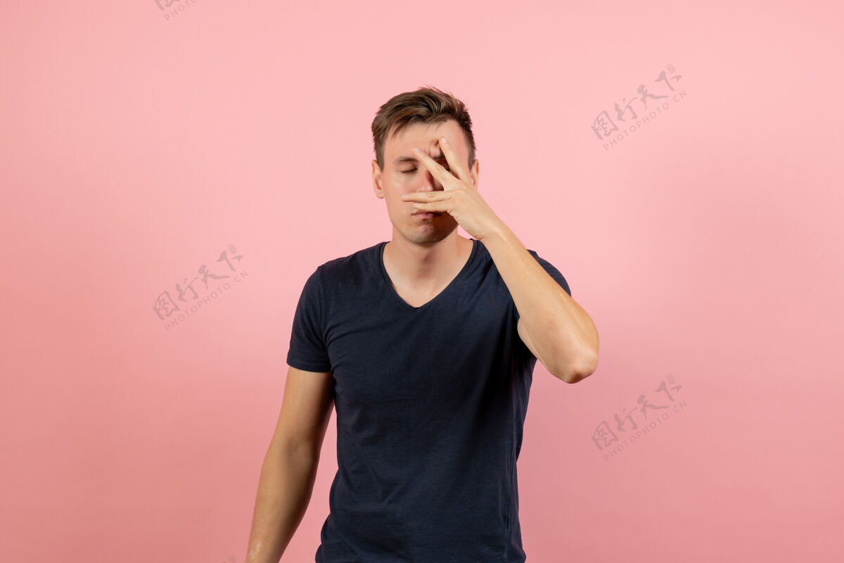 深蓝色正面图身穿深蓝色衬衫的年轻男性在粉色背景上遮住脸男性人类情感色彩男模男性肖像视图