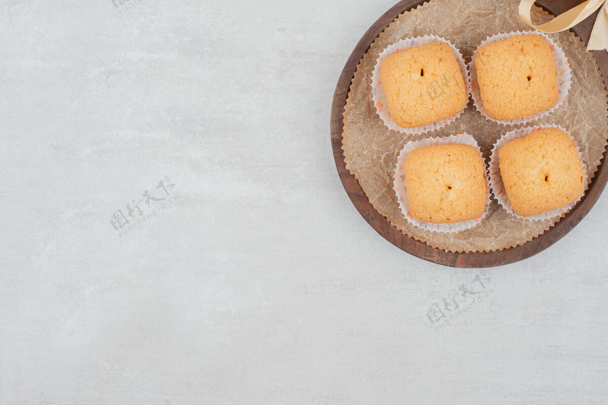 脆奶油甜饼放在饰有丝带的木盘上板美味饼干