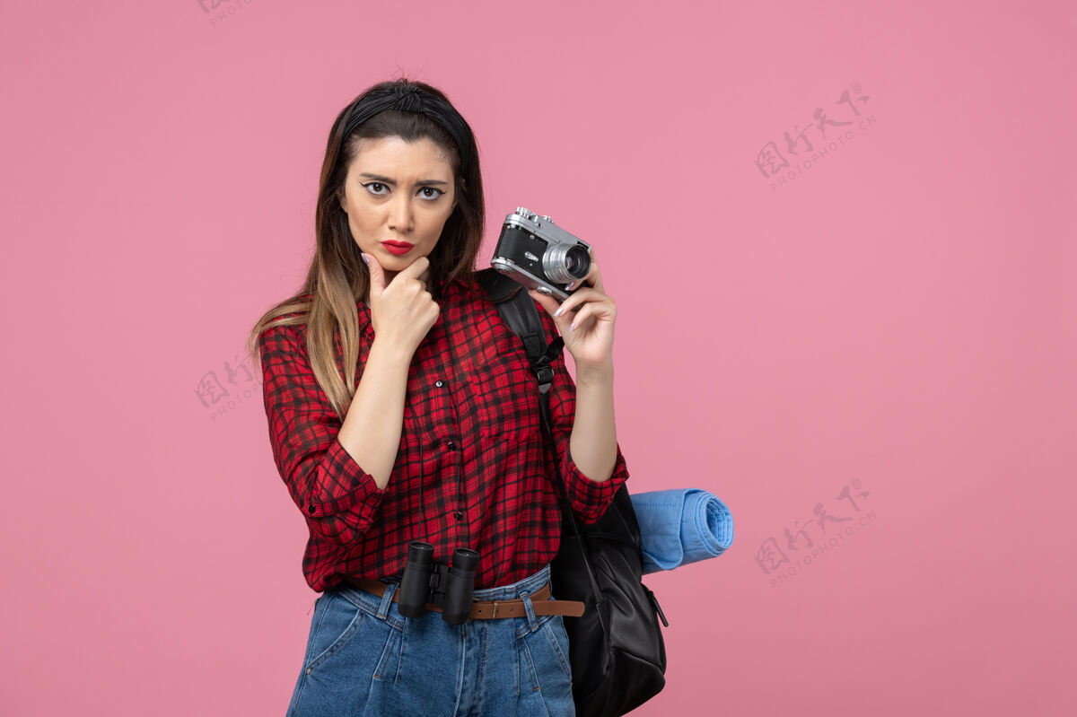 头发正面图：年轻女性用相机在粉色背景上拍照的女性照片模型拍摄女士照片