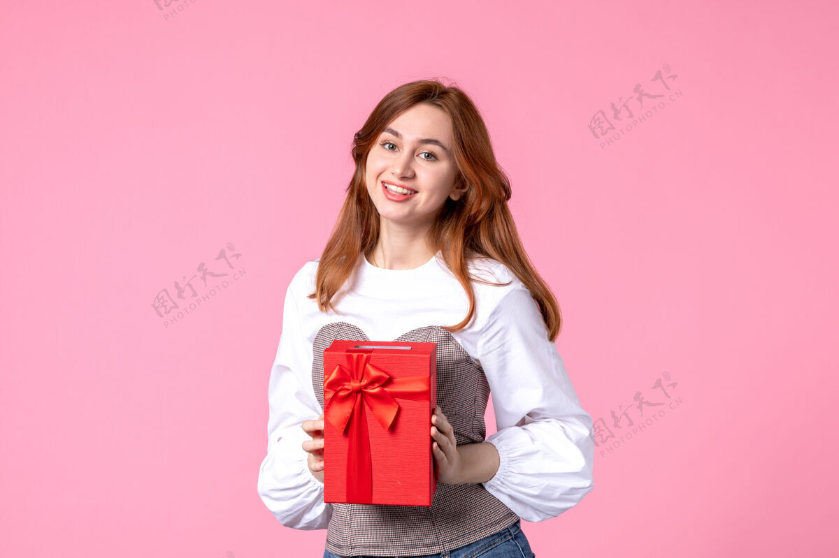 礼品正面图：年轻女性 红色包装 粉色背景 三月横向性感礼品 照片：金钱平等的女人香水礼品年轻女性
