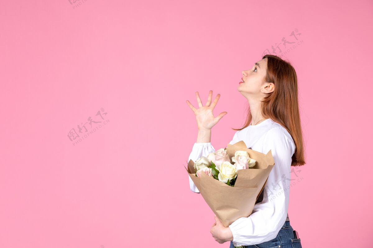 人正面图：年轻女性 带花朵 作为女性节礼物 粉色背景 横向 女性三月 爱情 性感 日期平等 玫瑰色花玫瑰年轻的女性
