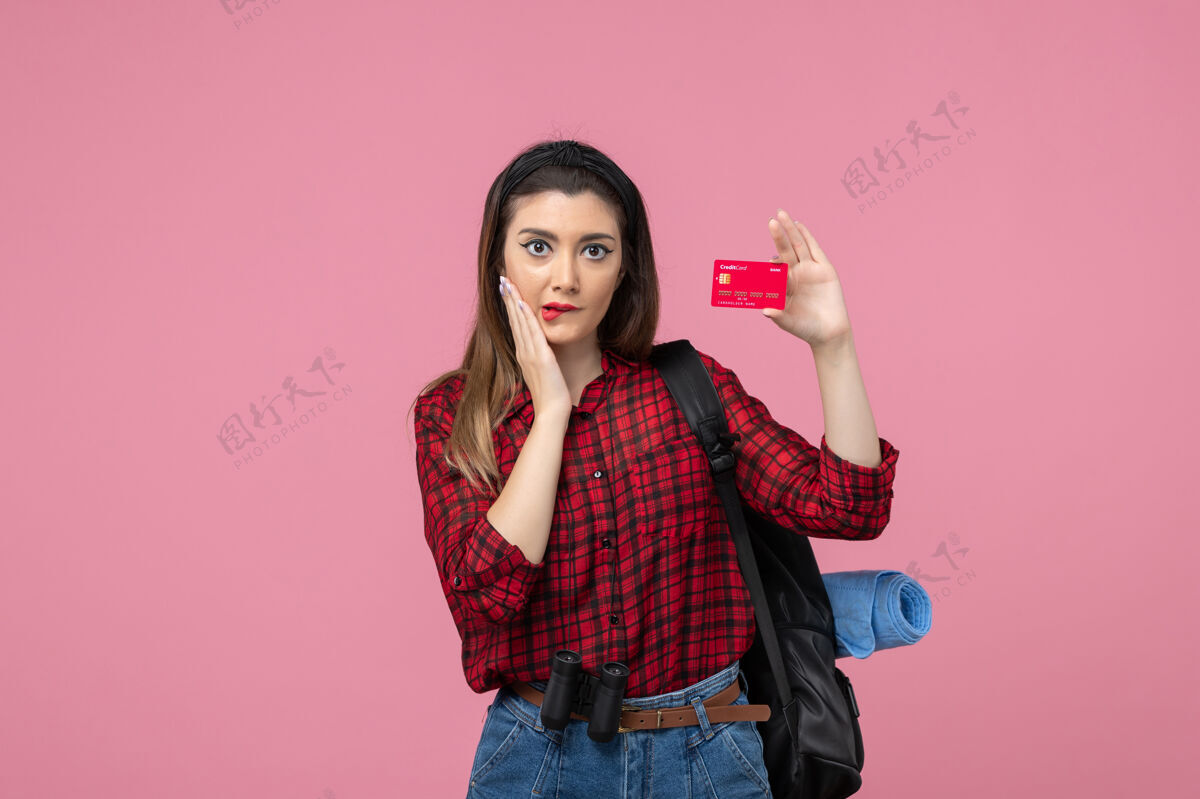 脸正面图身穿红色衬衫的年轻女性 背景为粉色的银行卡 女性颜色为人类女士肖像衣服
