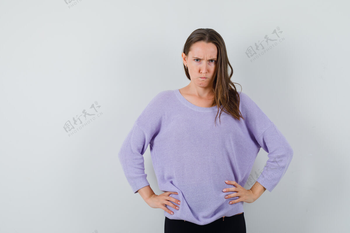 漂亮年轻的女性手放在腰上 穿着淡紫色的上衣 看起来很生气正面图手皮肤新鲜