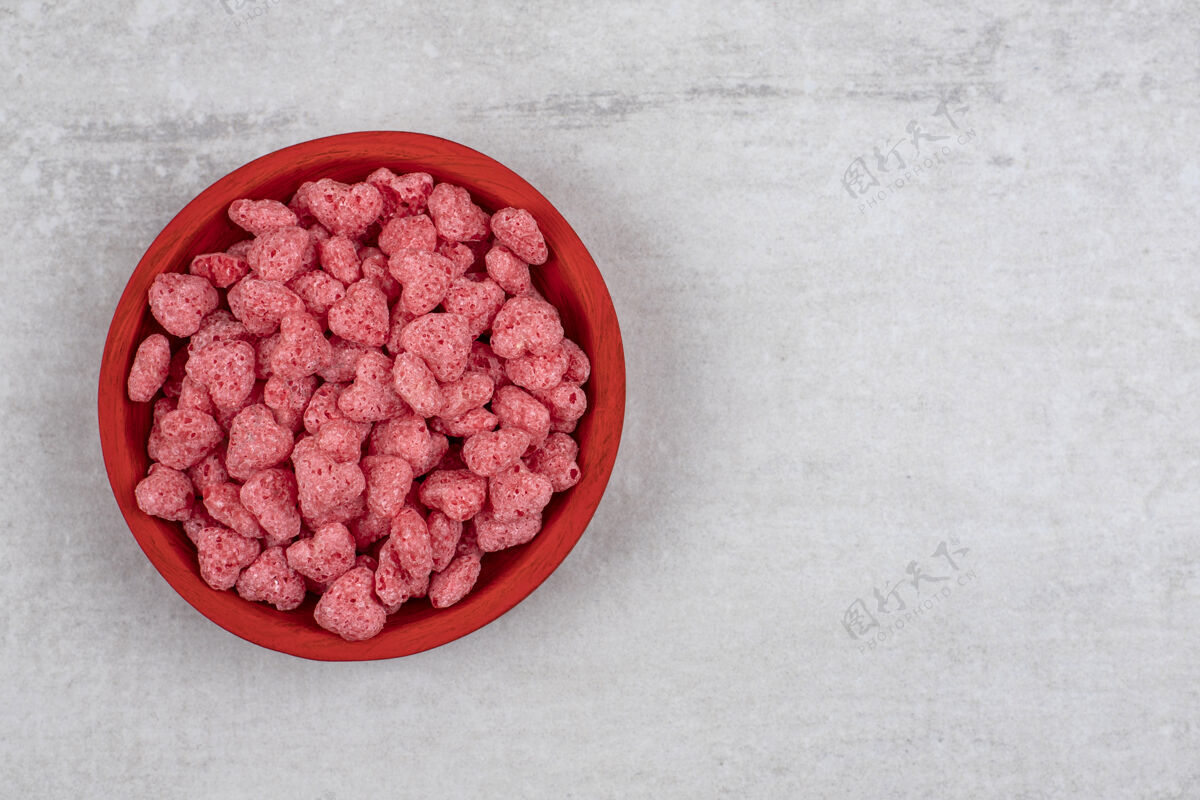复制空间石头桌上放满粉红色麦片的红碗顶视图美味谷类食品