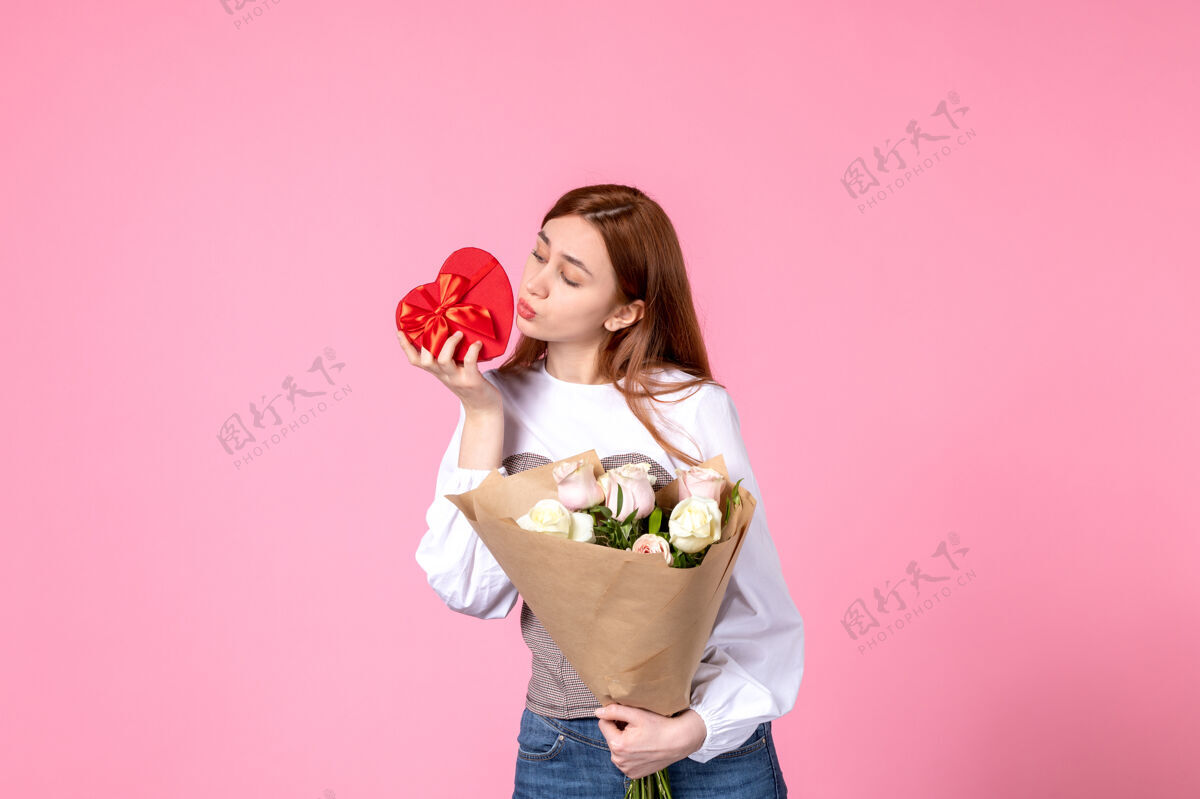 花束正面图：年轻女性 带鲜花 在粉色背景上作为妇女节礼物 水平三月平等女性约会女性爱感性玫瑰花礼物