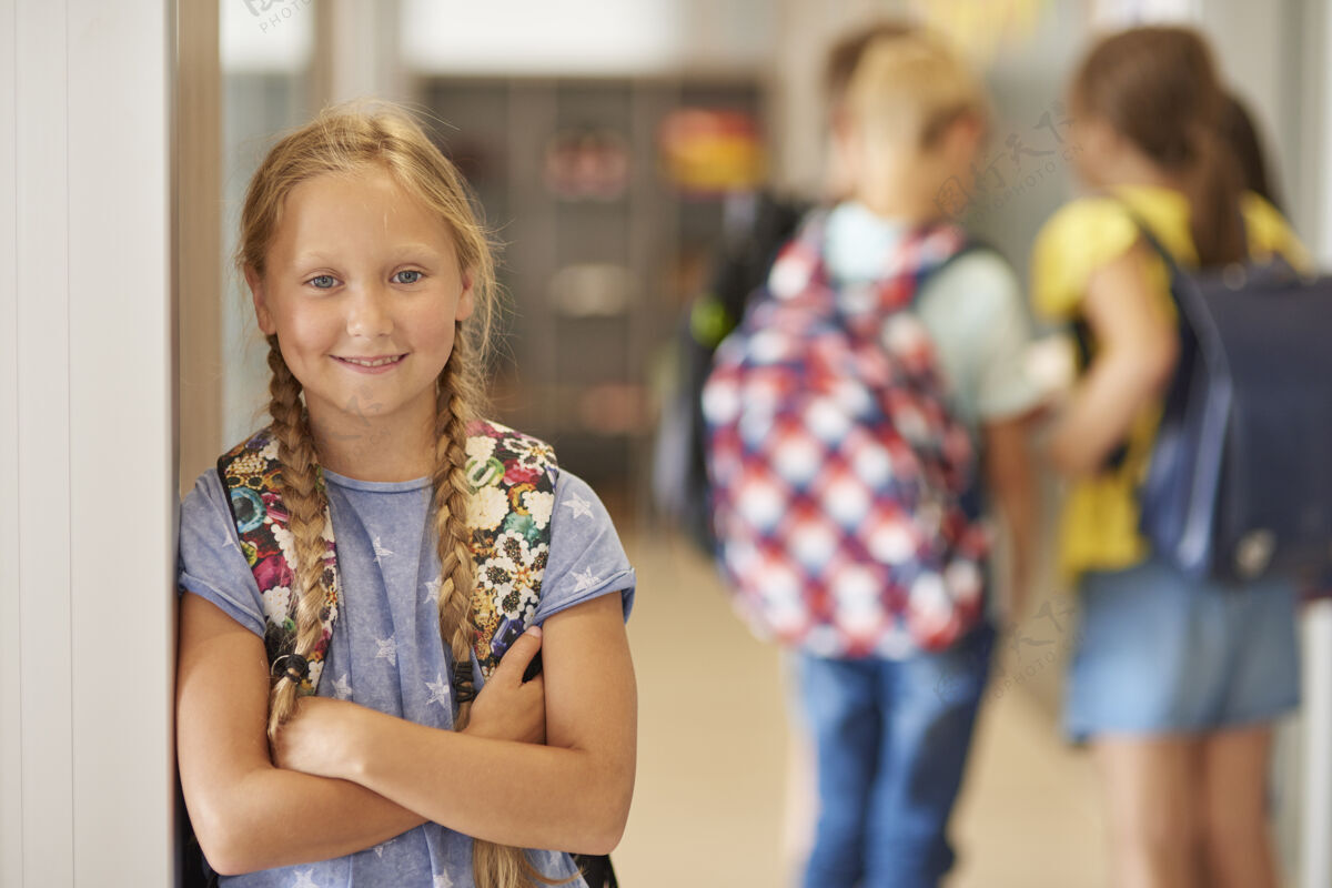 辫子学校走廊里背着背包的女孩的画像教育欢呼积极的情绪