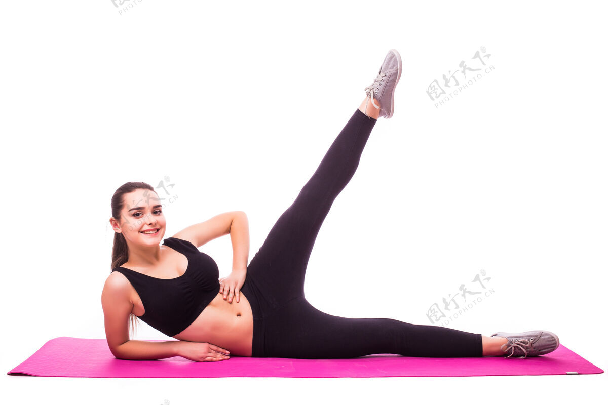 健身摄影棚拍摄的一个年轻的健康女子正在做瑜伽练习隔离在白色背景运动女孩锻炼