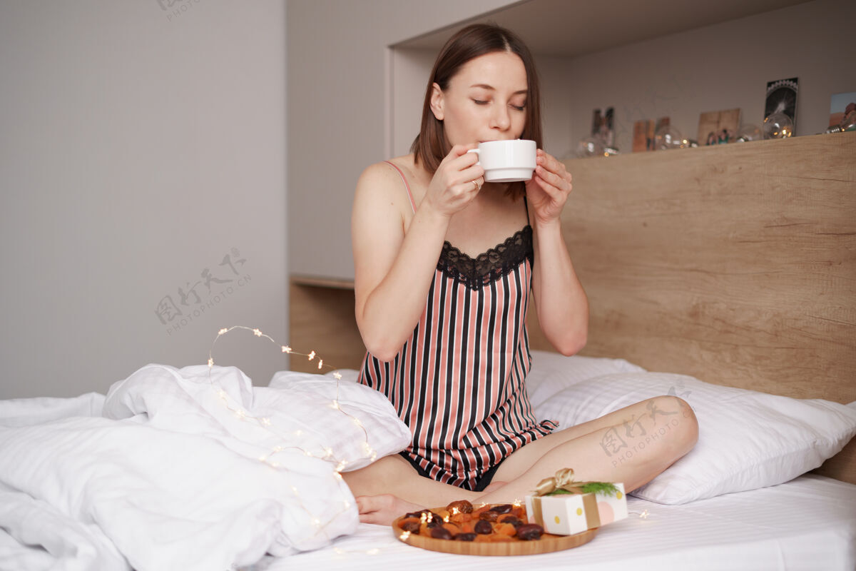 女人女人们在床上享受着带着棉花糖的咖啡 身边还有礼物谎言美味情人节