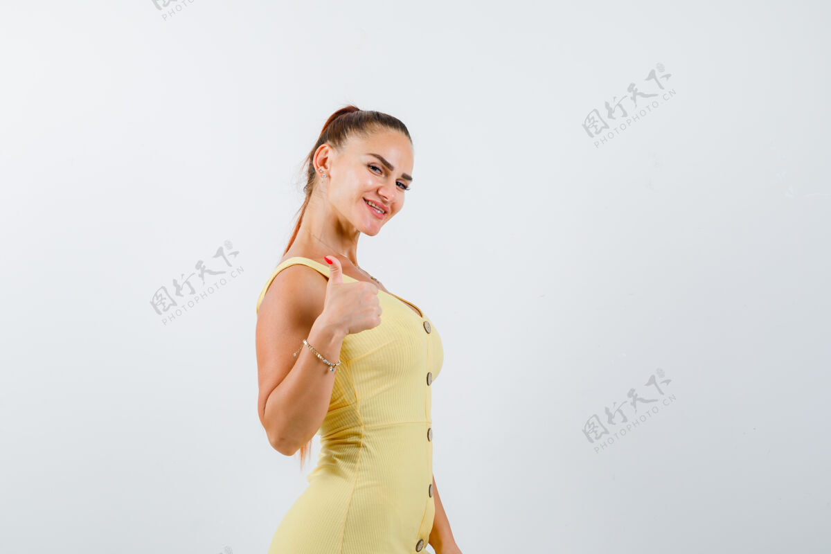互联网年轻漂亮的女性在穿着礼服摆姿势时竖起大拇指 看起来很幸福旅游应用程序智能